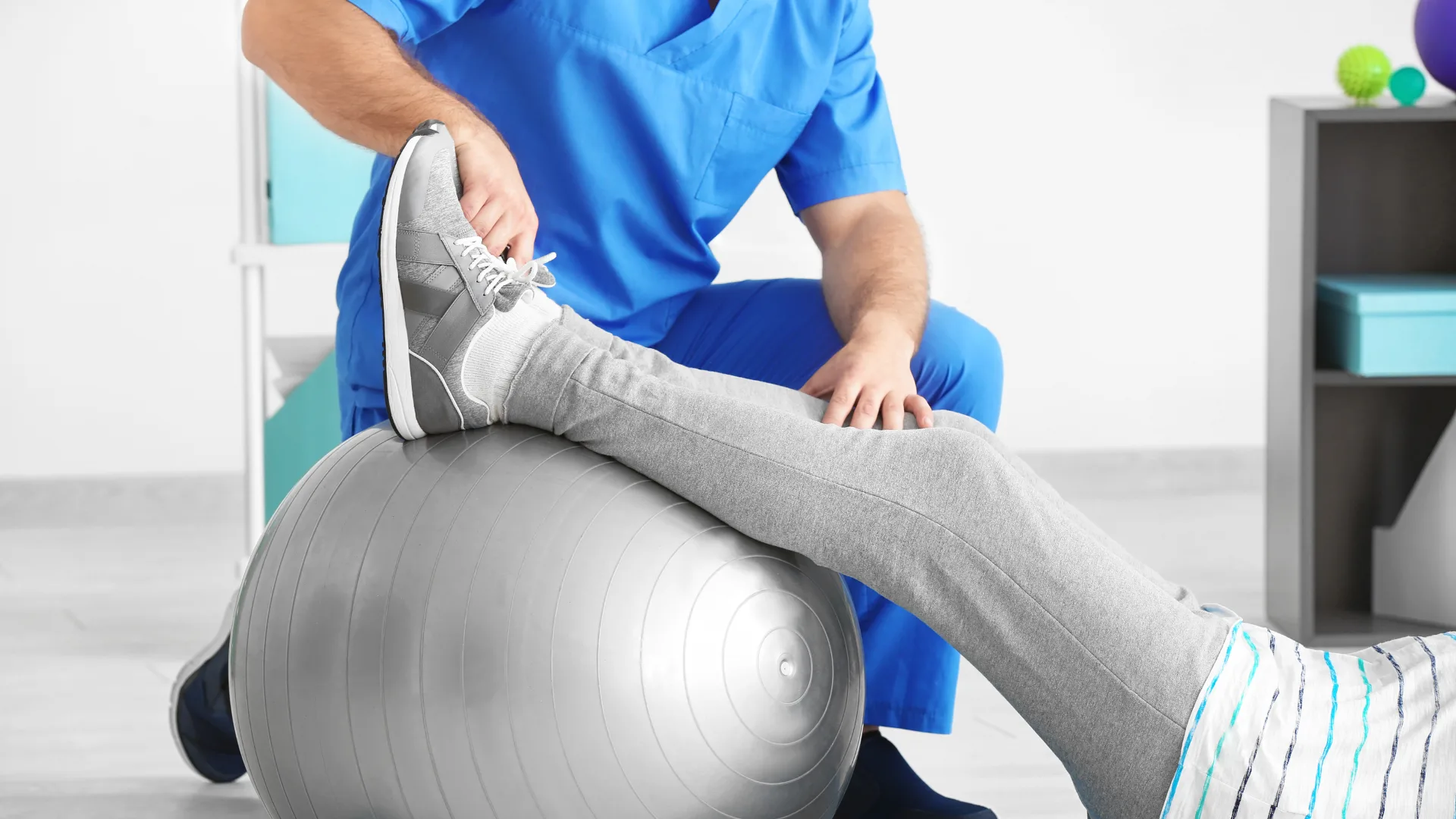 Therapeut führt eine Übung auf dem Gymnastikball